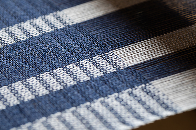 Detail of handwoven textile structure on a wooden loom at Ana & Francis Tejedores workshop
